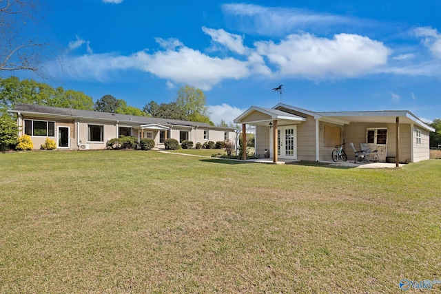 back of house featuring a lawn, french doors, and a patio area