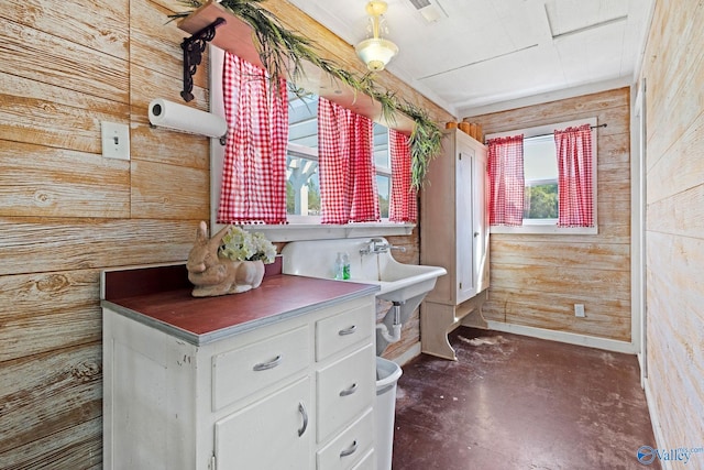 bathroom featuring wooden walls, visible vents, and finished concrete flooring