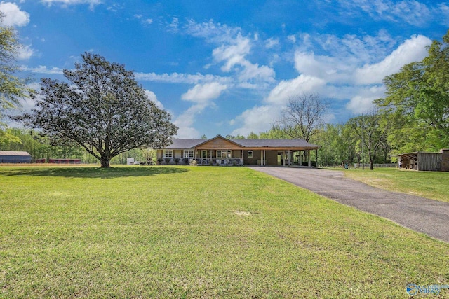ranch-style house with a carport, a front lawn, and driveway