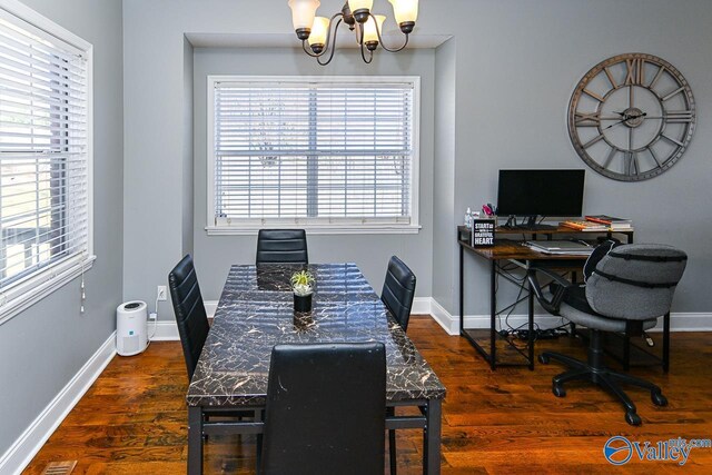 dining room with a notable chandelier, baseboards, and dark wood-type flooring