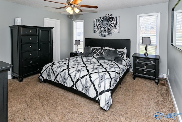 carpeted bedroom with a textured ceiling, a ceiling fan, and baseboards