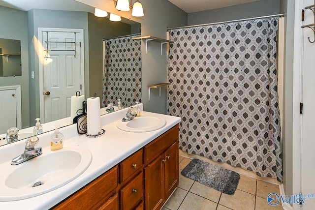 bathroom featuring tile patterned flooring, a sink, a shower with curtain, and double vanity