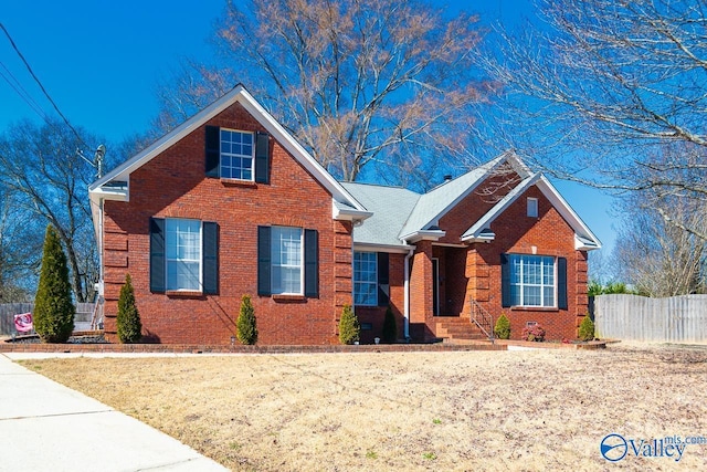 traditional home featuring brick siding, crawl space, and fence