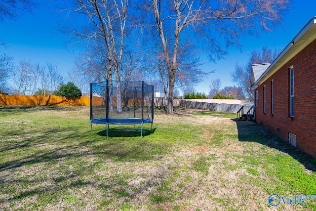 view of yard featuring a fenced backyard and a trampoline