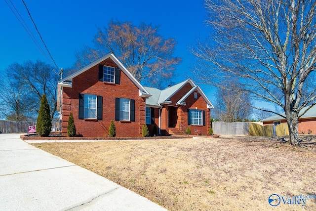 view of front of house with brick siding and fence