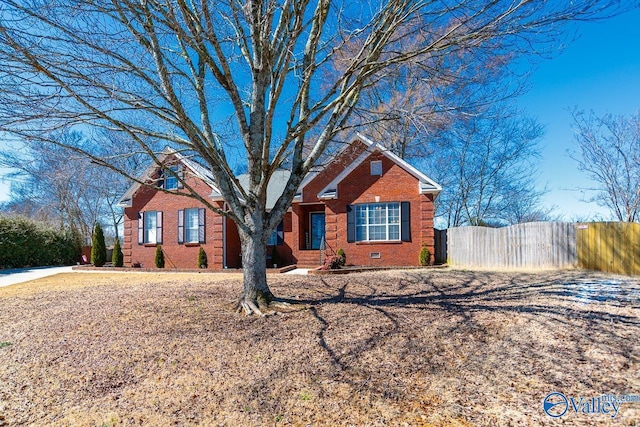 view of front of home featuring crawl space, fence, and brick siding