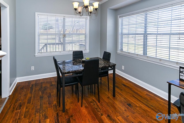 dining area featuring baseboards, dark wood finished floors, and an inviting chandelier