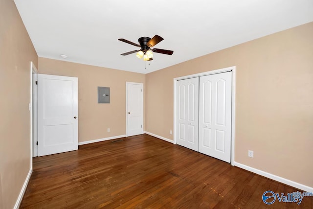 unfurnished bedroom with electric panel, baseboards, and wood finished floors