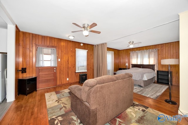 bedroom featuring a ceiling fan, wood finished floors, and freestanding refrigerator