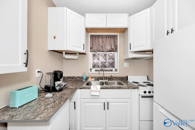 kitchen with under cabinet range hood, white appliances, a sink, white cabinets, and dark stone counters