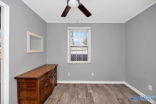 empty room featuring baseboards, wood finished floors, a ceiling fan, and crown molding