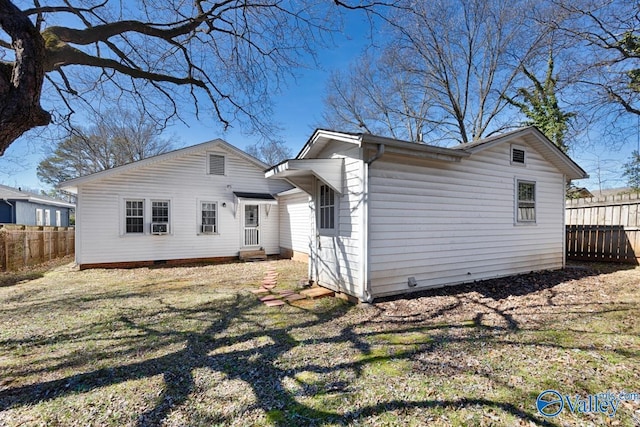 back of house with crawl space, fence, a lawn, and entry steps