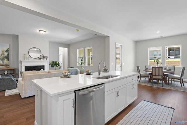 kitchen with open floor plan, stainless steel dishwasher, a sink, and dark wood finished floors
