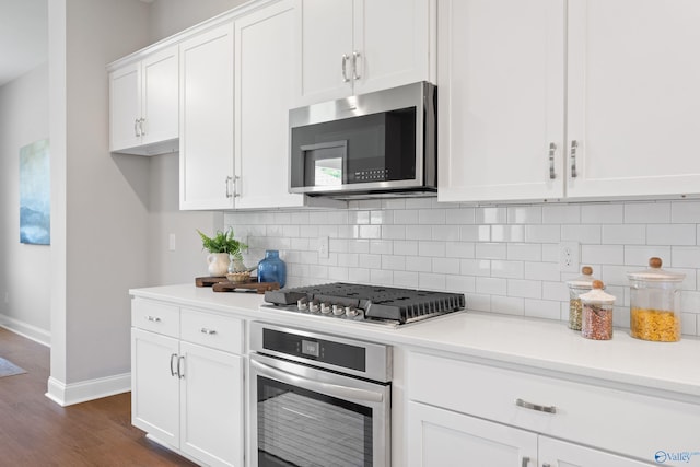 kitchen featuring white cabinets, light countertops, appliances with stainless steel finishes, dark wood finished floors, and backsplash