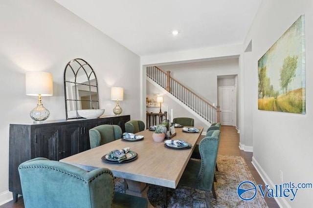 dining room featuring stairway, baseboards, and wood finished floors
