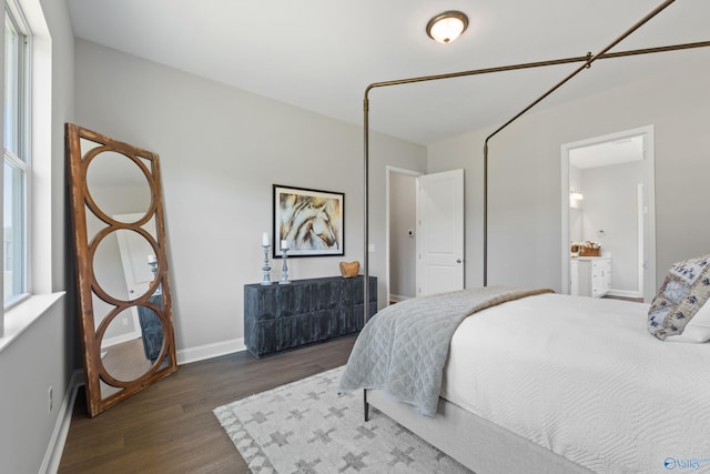 bedroom with ensuite bathroom, baseboards, and wood finished floors