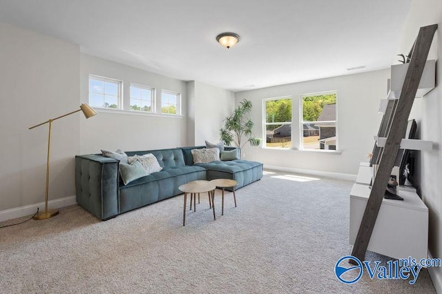 living area featuring carpet flooring, baseboards, and plenty of natural light
