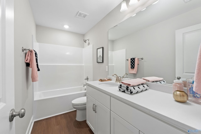 bathroom featuring vanity, shower / bath combination, toilet, visible vents, and wood finished floors
