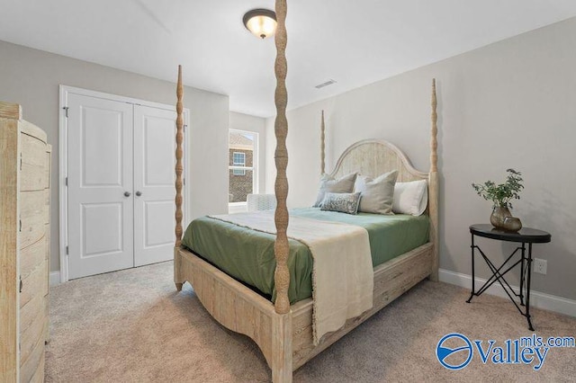 carpeted bedroom with visible vents, baseboards, and a closet