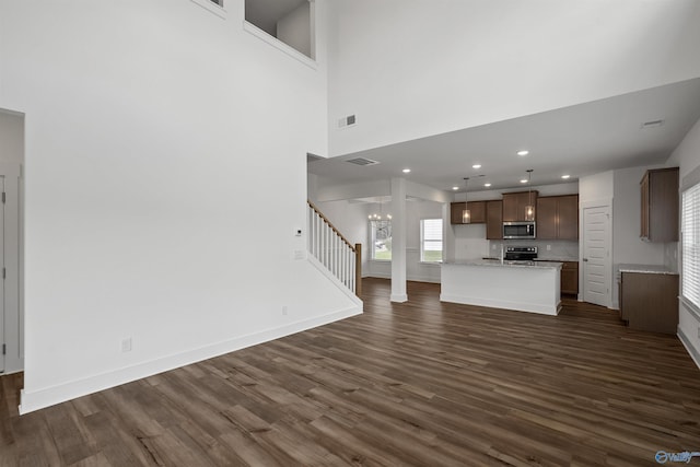 unfurnished living room with baseboards, visible vents, dark wood-style flooring, a chandelier, and recessed lighting