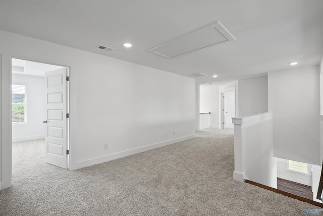 carpeted spare room featuring attic access, recessed lighting, visible vents, and baseboards