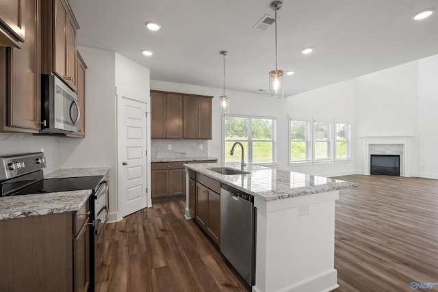 kitchen featuring appliances with stainless steel finishes, a premium fireplace, sink, decorative backsplash, and dark wood-type flooring