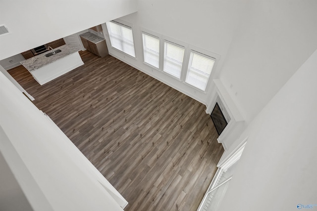 living area with visible vents, dark wood finished floors, and a towering ceiling