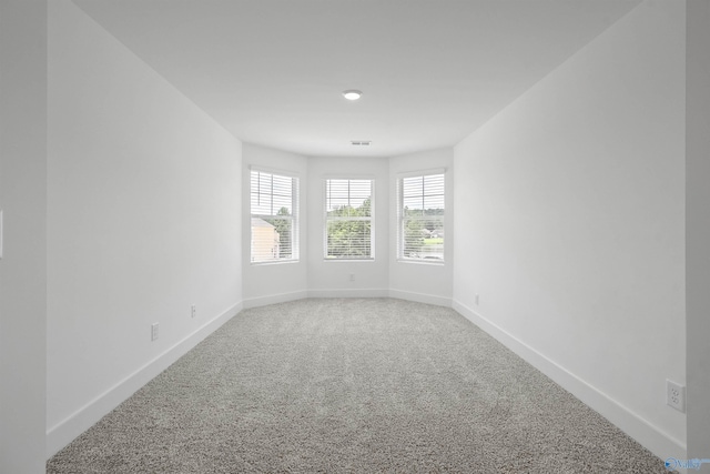 carpeted empty room featuring visible vents and baseboards