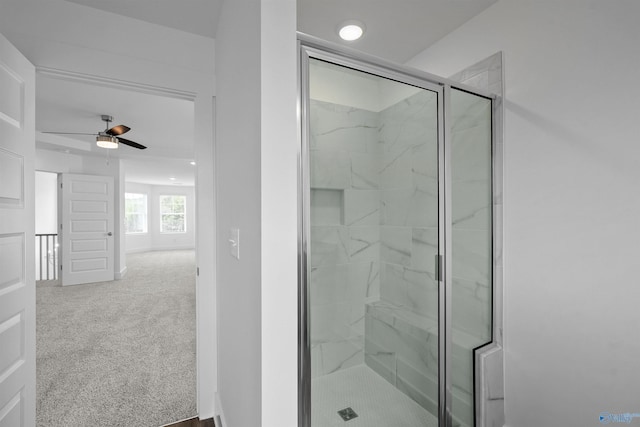 full bath featuring a ceiling fan and a marble finish shower