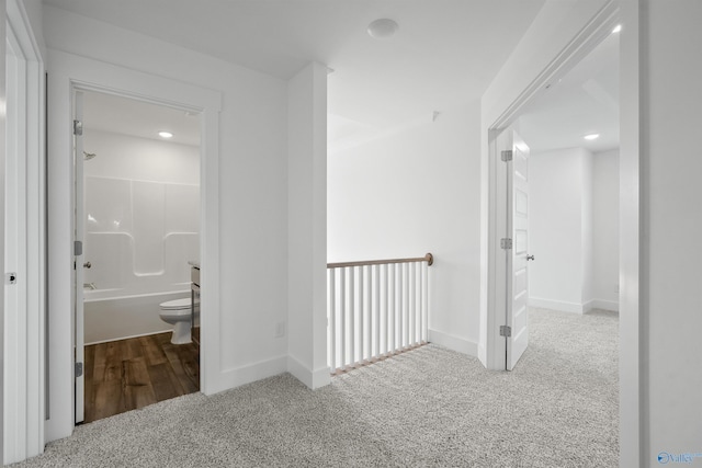 hallway featuring carpet floors and baseboards