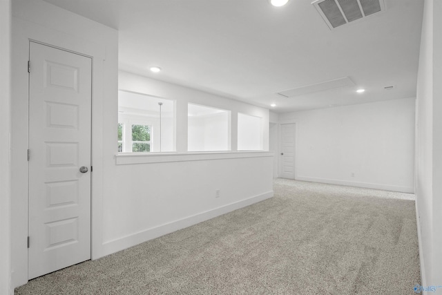 empty room featuring attic access, visible vents, baseboards, light colored carpet, and recessed lighting