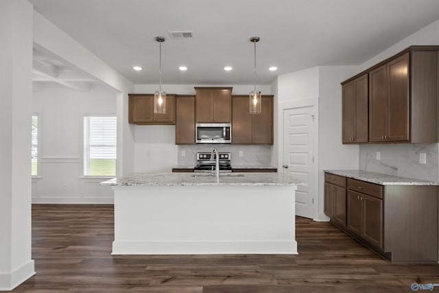 kitchen featuring hanging light fixtures, a center island with sink, visible vents, and stainless steel appliances