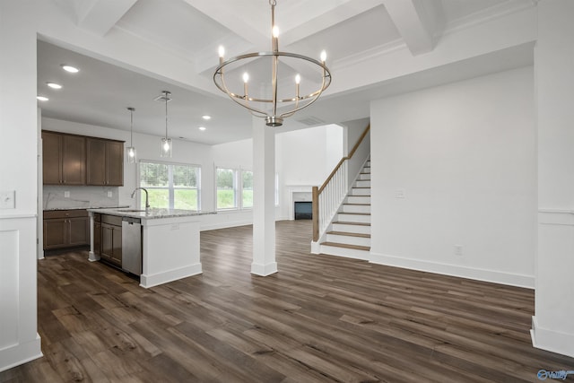 kitchen with open floor plan, stainless steel dishwasher, light stone countertops, an island with sink, and decorative light fixtures