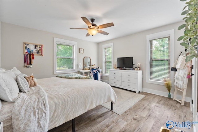 bedroom featuring baseboards, a ceiling fan, and wood finished floors