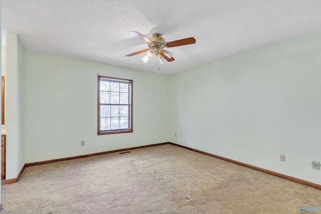 empty room with a textured ceiling, ceiling fan, and carpet