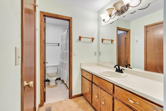 bathroom featuring toilet, a textured ceiling, and vanity