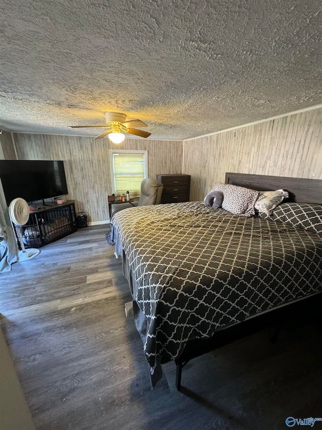 bedroom with ceiling fan, wood-type flooring, and a textured ceiling