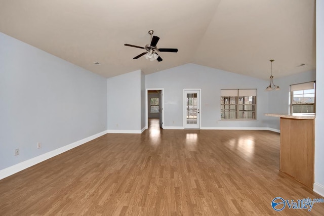 unfurnished living room featuring hardwood / wood-style flooring, ceiling fan, and vaulted ceiling