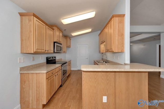 kitchen featuring appliances with stainless steel finishes, sink, kitchen peninsula, light brown cabinets, and light hardwood / wood-style flooring