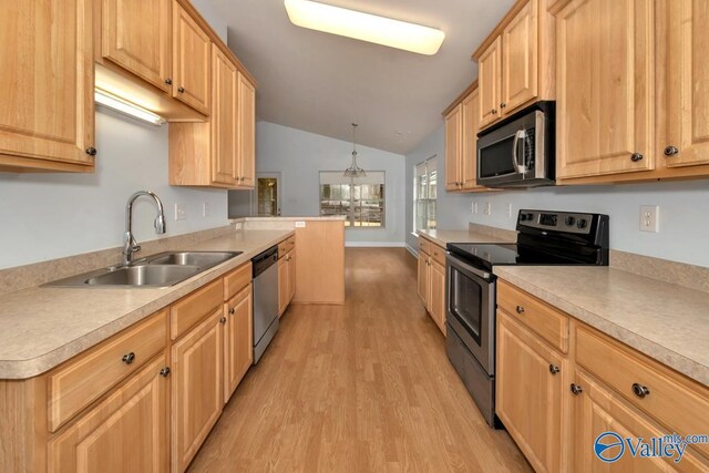 kitchen featuring lofted ceiling, sink, decorative light fixtures, light wood-type flooring, and appliances with stainless steel finishes