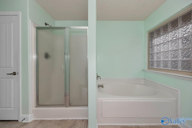 bathroom with separate shower and tub and tile patterned flooring