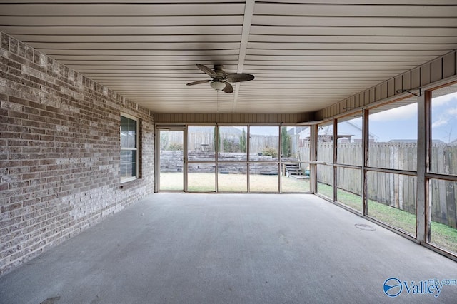 unfurnished sunroom featuring ceiling fan and plenty of natural light