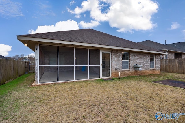 back of property with a sunroom and a yard