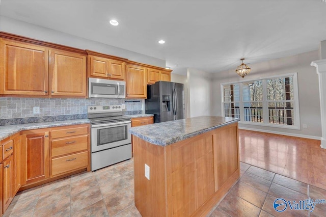 kitchen featuring a chandelier, recessed lighting, stainless steel appliances, a kitchen island, and decorative backsplash