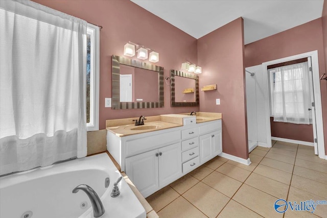 bathroom featuring tile patterned flooring, a sink, baseboards, a jetted tub, and double vanity