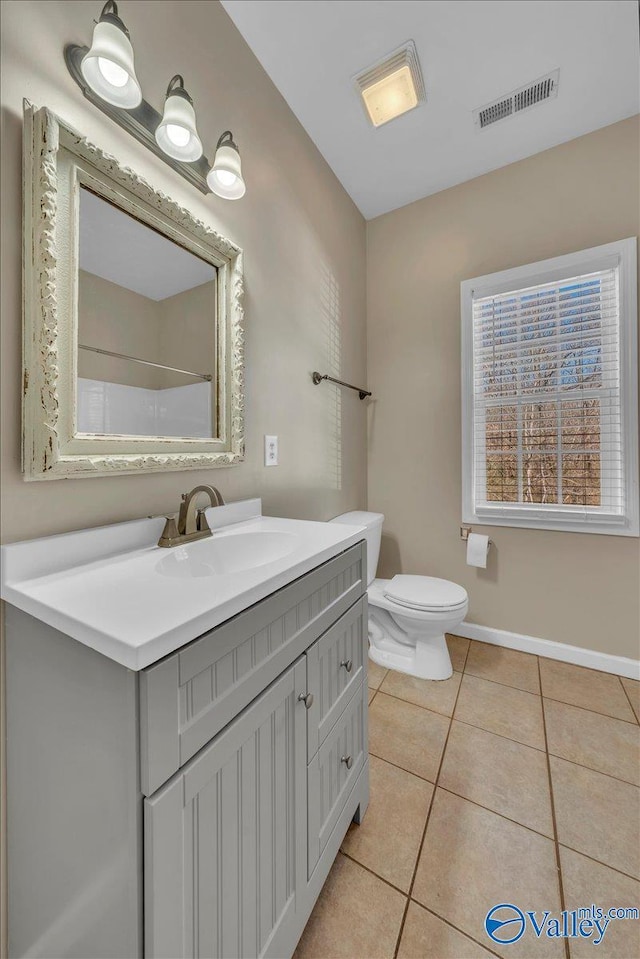 full bathroom featuring toilet, vanity, baseboards, visible vents, and tile patterned floors