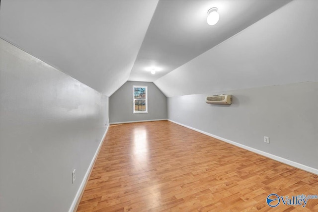 additional living space featuring lofted ceiling, baseboards, and wood finished floors