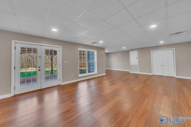 unfurnished living room with french doors, wood finished floors, visible vents, and baseboards