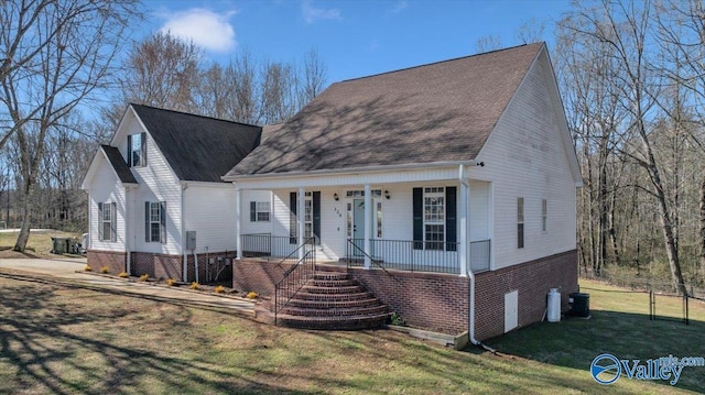 view of front of house with a porch, a front yard, brick siding, and cooling unit