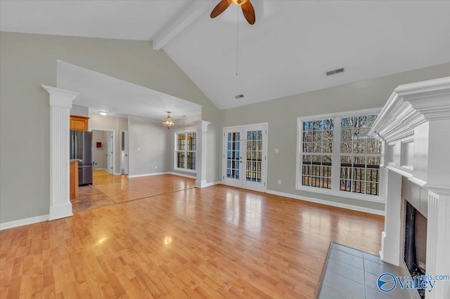 unfurnished living room with light wood finished floors, visible vents, a fireplace with flush hearth, beam ceiling, and ceiling fan with notable chandelier